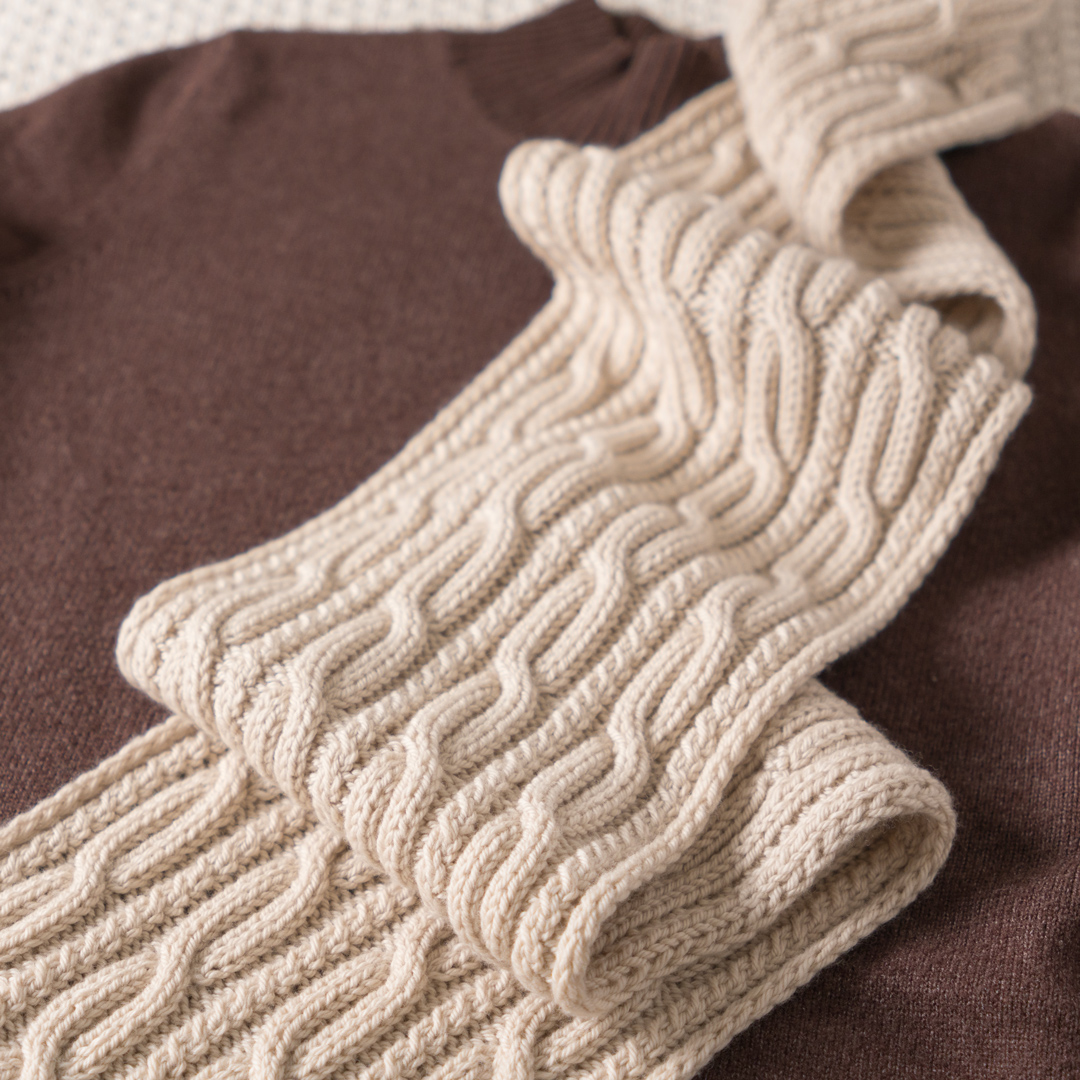 Close up on a knitted cable scarf.