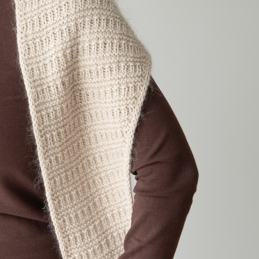 Knitted triangular scarf.